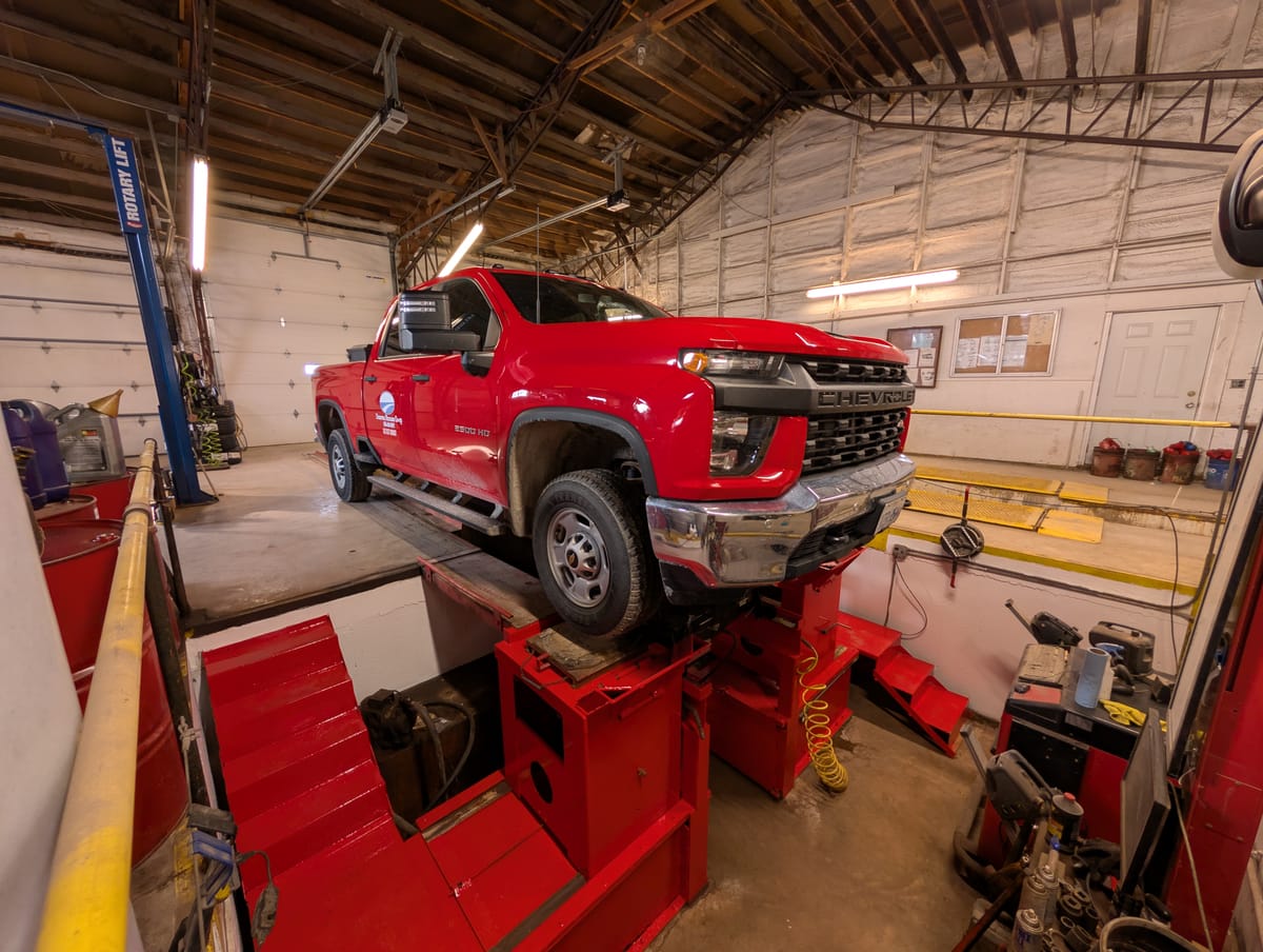 Red Chevy truck on the alignment rack
